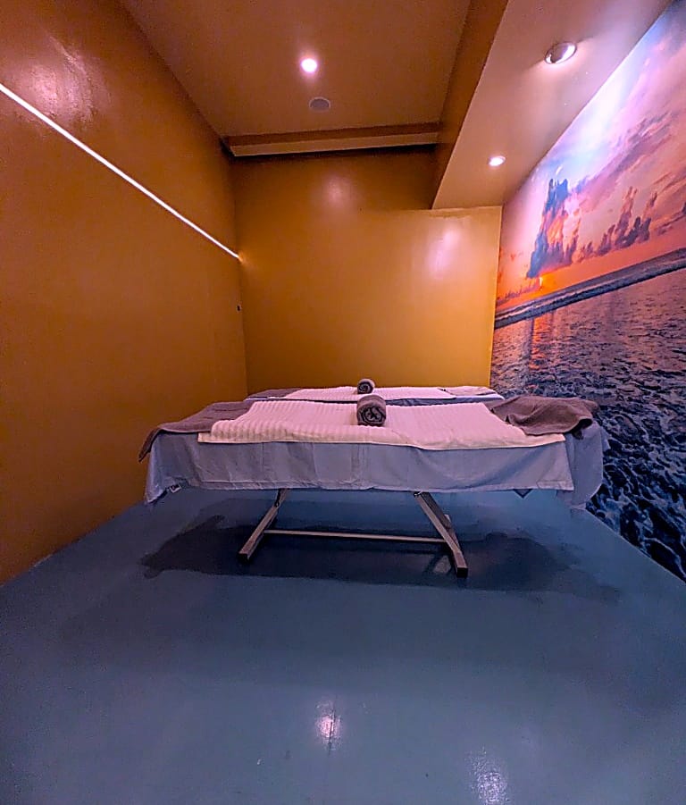 Private couples massage room with sunset ocean mural at Masaje Milagroso Cacho Tijuana Plaza ETU